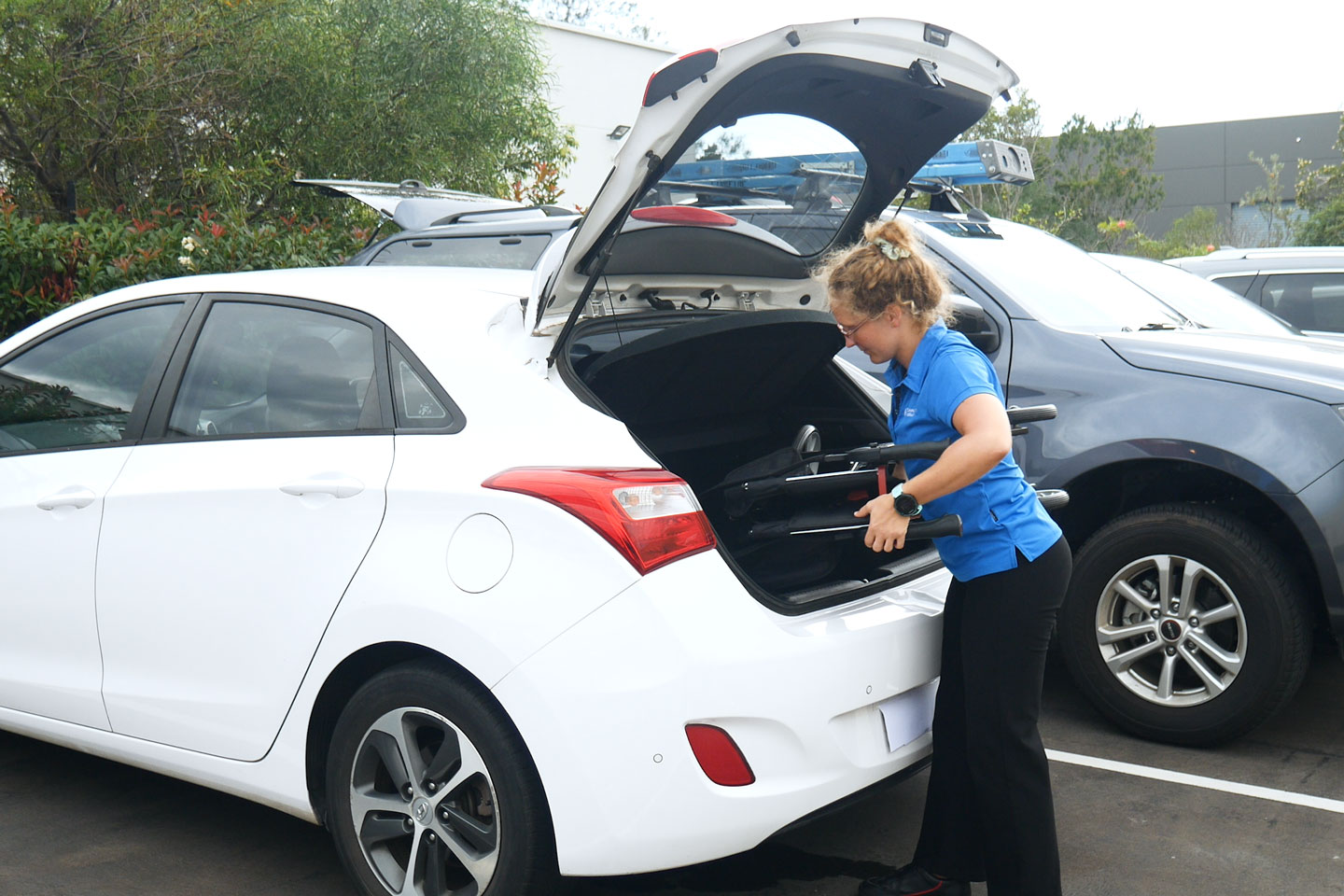 Clinician getting a wheelchair in the boot of a car