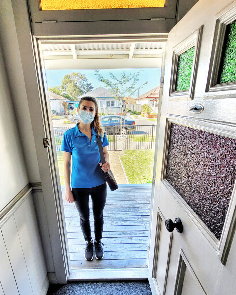 Clinician standing at someone's front door