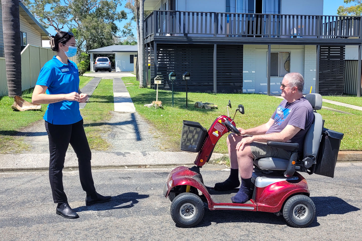 Occupational Therapist talking to a client on a mobility scooter