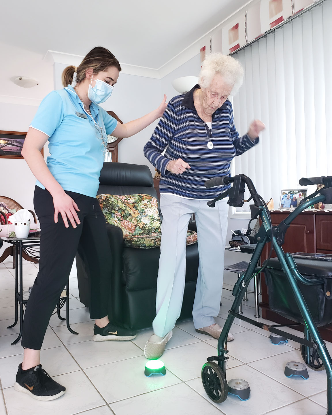 Physiotherapist supporting an older adult while utilising Blaze Pods for exercise