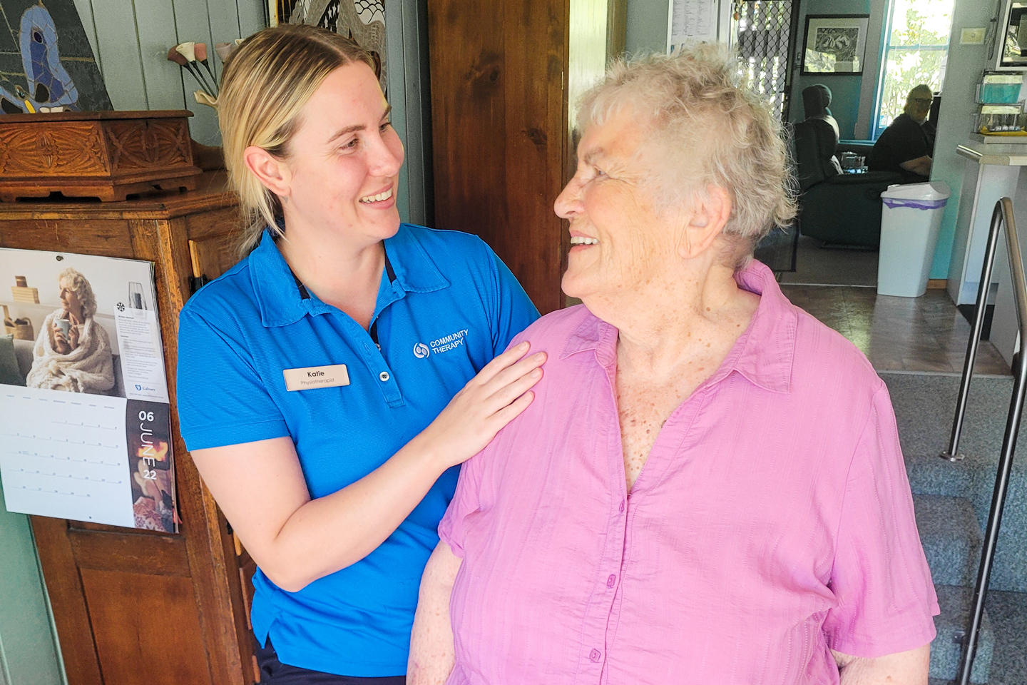 Clinician assisting an aged care client to walk