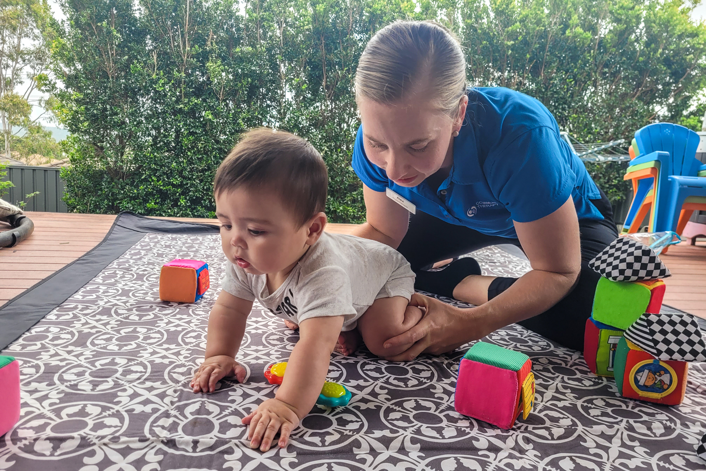 Paeds Physiotherapist supporting a baby's lower limbs and hips while crawling