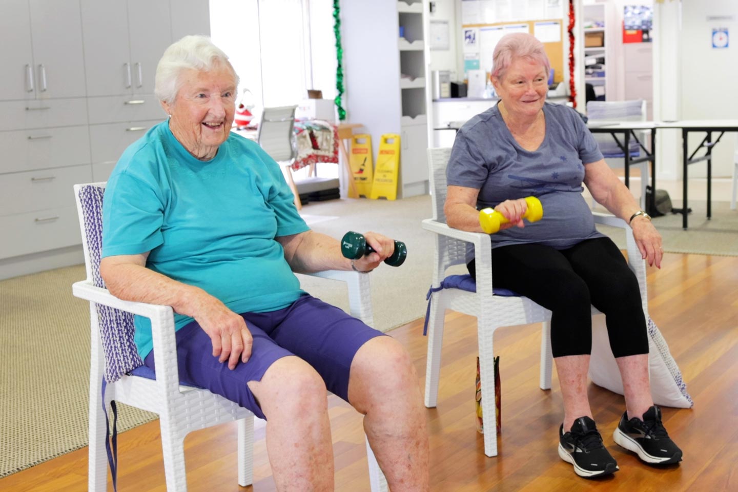 Two female seniors holding dumbbells