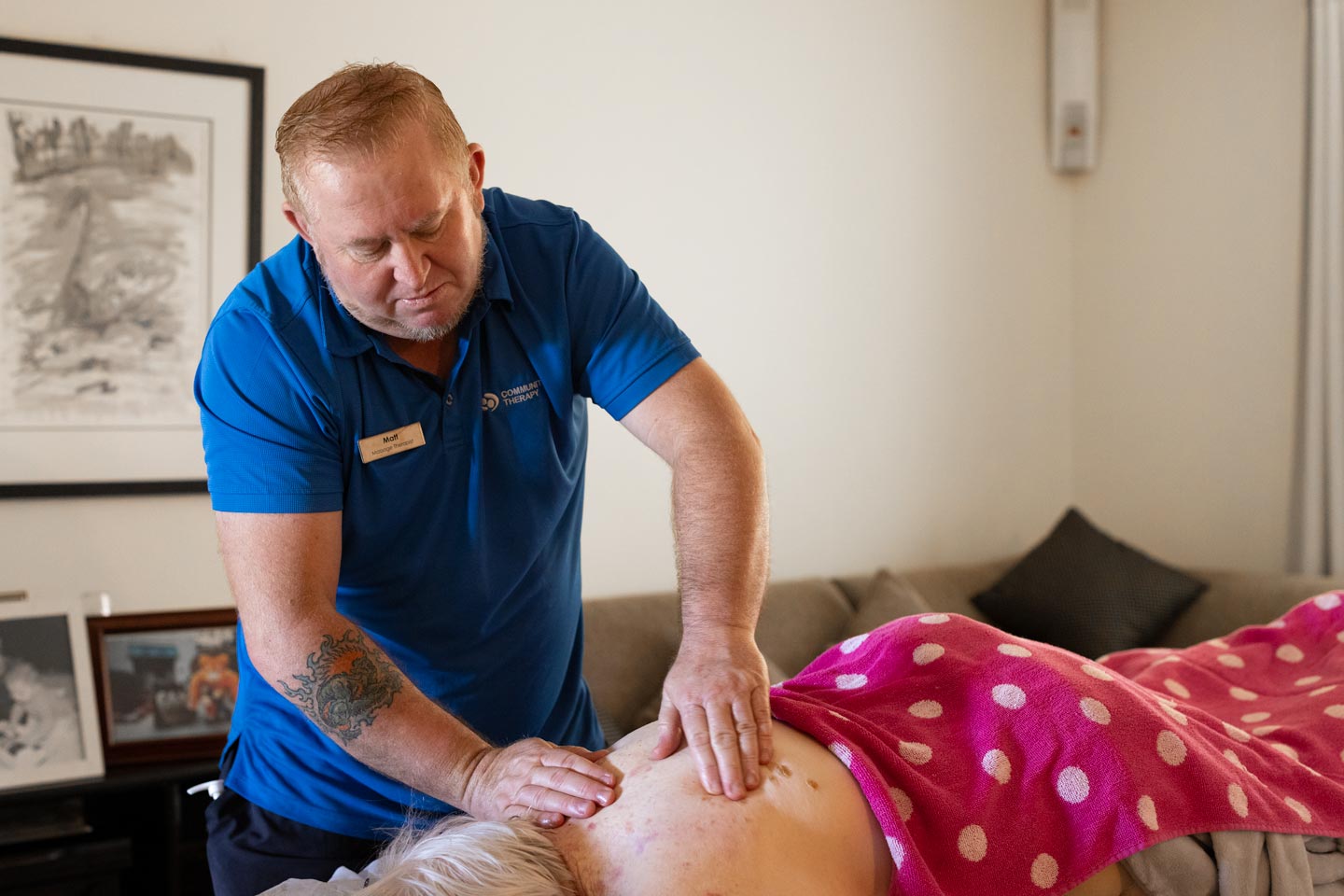 Male massage therapist and client on plinth 