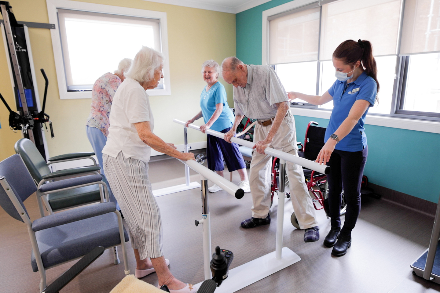 Group of older adults doing lower limb exercises with a Physiotherapist