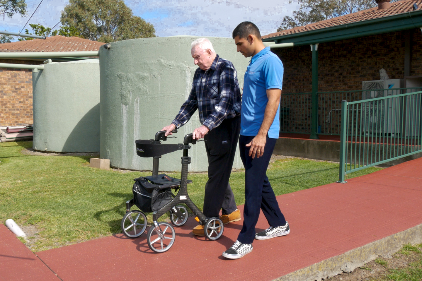 Physiotherapist supporting and older adult with a walker